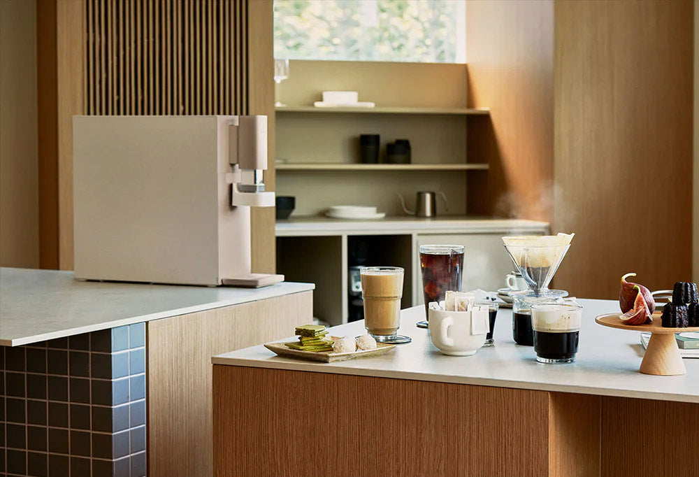 CUCKOO STEAM 100 Barista Water Purifier on a modern kitchen counter with coffee drinks, accompanied by promotional text. (cp-abnc100)