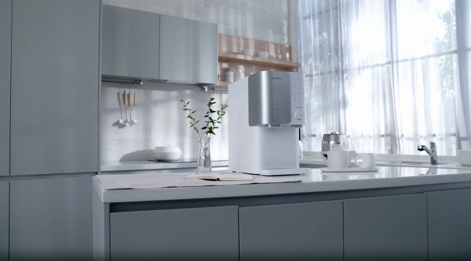 A white and silver Cuckoo water purifier